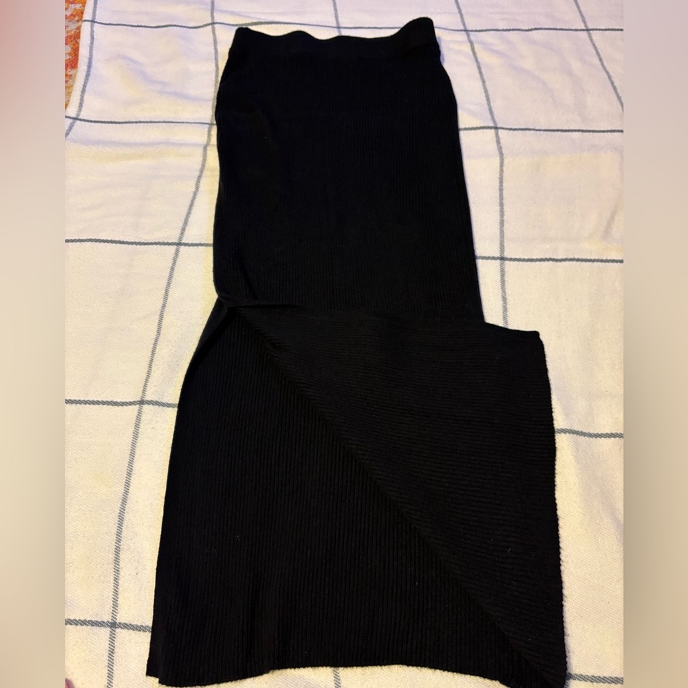 Elegant black ribbed midi skirt with side slit. Slit runs on the right side.